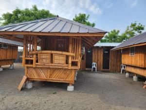 a wooden building with a roof on top of it at Beachfront Aircon Kubo for 4pax in Caba