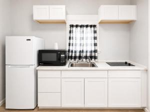 a white kitchen with a sink and a refrigerator at Royal Gateway Motel in Bend