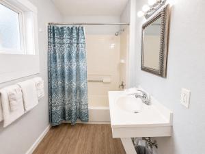 a white bathroom with a sink and a mirror at Royal Gateway Motel in Bend +55 photos