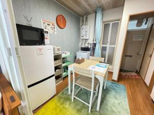 a small kitchen with a table and a refrigerator at サイプレス平岸 in Sapporo