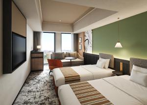 a hotel room with two beds and a television at Premium hotel MONday MAIHAMA VIEW 2 in Tokyo