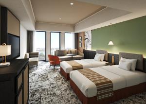 a hotel room with two beds and a couch at Premium hotel MONday MAIHAMA VIEW 2 in Tokyo