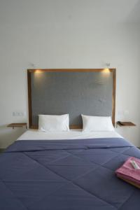 a bedroom with a large bed with a large headboard at Vagamon Hill Resort in Vagamon +6 photos
