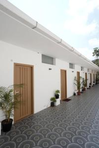 a row of doors on a white building with plants at Vagamon Hill Resort in Vagamon