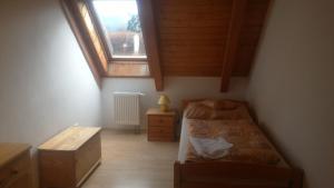 a small bedroom with a bed and a window at Apartment Lipno in Lipno nad Vltavou