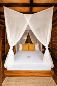 a bed in a room with a mosquito net at Luma by Zakua in Guachaca