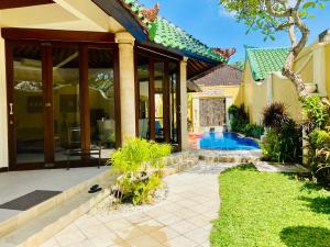 a house with a swimming pool in a yard at Bali Emerald Villas in Sanur