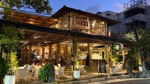 ein Restaurant mit Tischen und Stühlen vor einem Gebäude in der Unterkunft Sari Bunga Hotel - Legian, walking distance to Legian Beach in Legian