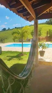 a hammock on a patio with a pool at Recanto do Batata in Atibaia