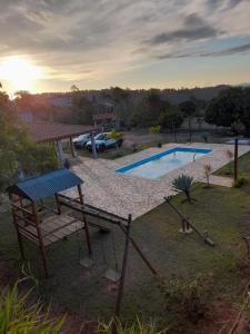 a swimming pool with a swing and a playground at Recanto do Batata in Atibaia