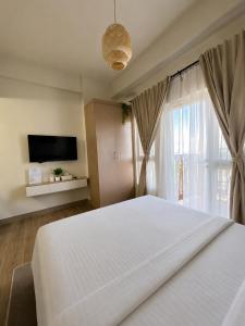 a bedroom with a large white bed and a window at Boho-Nordic Studio at Twin Lakes Vineyard, Tagaytay by Cozy Escape in Laurel