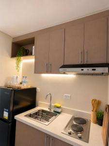a kitchen with a sink and a black refrigerator at Boho-Nordic Studio at Twin Lakes Vineyard, Tagaytay by Cozy Escape in Laurel