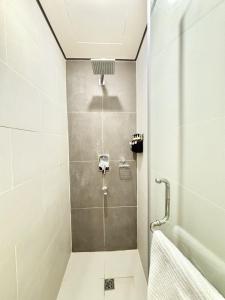 a shower with a glass door in a bathroom at Boho-Nordic Studio at Twin Lakes Vineyard, Tagaytay by Cozy Escape in Laurel