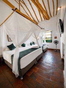 a bedroom with a bed with a mosquito net at Posada Sueños de Antonio in Barichara
