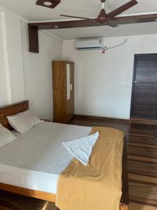 a bedroom with a bed and a ceiling fan at morriz inn in Kalpetta