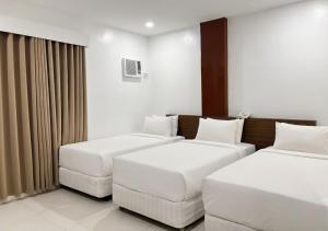 a hotel room with two beds and a couch at Cris Inn - Bayugan in Bayugan City +16 photos