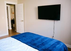 a bed with a blue blanket and a flat screen tv at Modern Condo • Safe Chicago Stay Near O’Hare in Chicago