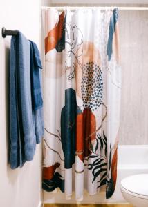 a shower curtain in a bathroom next to a toilet at Modern Condo • Safe Chicago Stay Near O’Hare in Chicago
