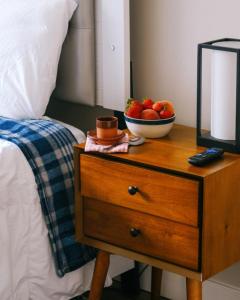 a bowl of fruit on a night stand next to a bed at Modern Condo • Safe Chicago Stay Near O’Hare in Chicago