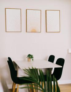 a dining room table with black chairs and pictures on the wall at Modern Condo • Safe Chicago Stay Near O’Hare in Chicago +16 photos