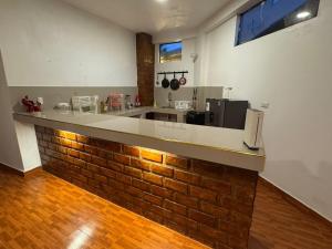 a kitchen with a brick wall and a counter top at New Experiences Valle sagrado in Urubamba