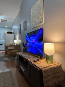 a living room with a tv on a table with a lamp at Jefferson Carriage House Hideaway in Huntington