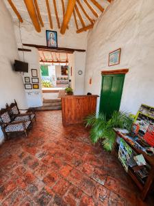 a living room with a green door and a brick floor at Posada Sueños de Antonio in Barichara