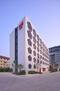 a coca cola building with a bunch of signs on it at Go Hotel Khon Kaen Campas in Ban Nong Waeng