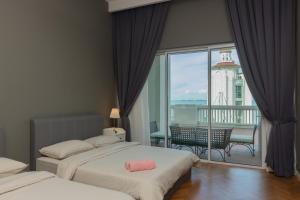 a hotel room with two beds and a balcony at Straits Quay Waterside Penang in Tanjong Tokong +66 photos