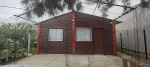 a small wooden house with two windows at Cabaña Dos Pinos in Durazno