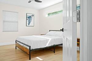 a white bedroom with a bed and a window at Ocean Retreat C in Boynton Beach