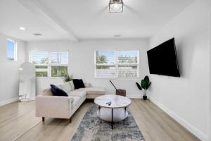 a white living room with a couch and a table at Ocean Retreat C in Boynton Beach