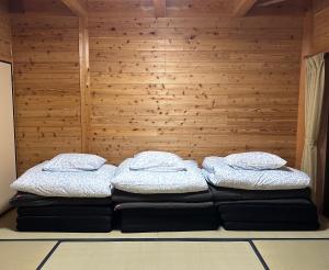 two beds sitting on a couch in a room at Lodge Kurokawa 2 Forest in Minamioguni