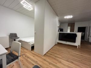a white room with a bed and a tv in it at bei gitta in Olpe