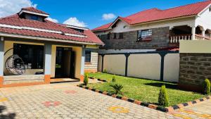 a house with a red roof and a yard at Godly Homes in Ruiru