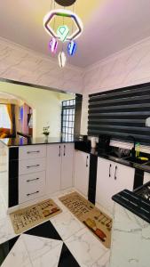 a kitchen with white cabinets and a chandelier at Godly Homes in Ruiru