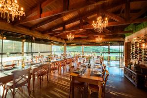 a large dining room with tables and chairs and chandeliers at Pipas Terroir & Domos Perlage - Experiências Únicas no Vale dos Vinhedos in Bento Gonçalves +75 photos