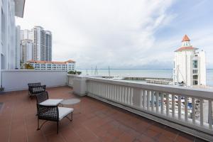 a balcony with chairs and a view of the ocean at Straits Quay Waterside Penang in Tanjong Tokong