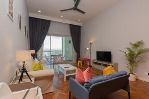 a living room with a couch and a tv at Straits Quay Waterside Penang in Tanjong Tokong