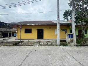 a yellow building with a pole in front of it at Sonrisas in Iquitos
