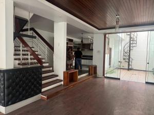 a man is standing in a living room with a staircase at Sonrisas in Iquitos
