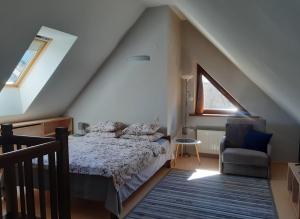 a attic bedroom with a bed and a chair at Lazdas in Saulkrasti