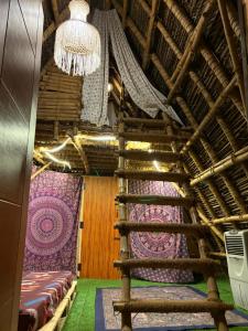 a staircase in a room with a curtain and a chandelier at v kudil in Auroville