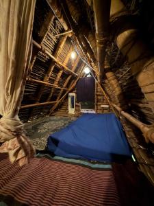 a room with a blue bed in a hut at v kudil in Auroville +11 photos