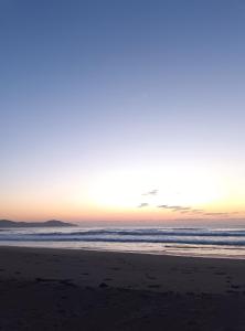 a sunset on a beach with the ocean at 黒潮の家 ドミトリー in Kuroshio
