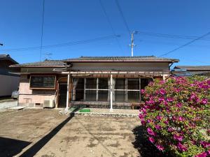 a house with purple flowers in front of it at 黒潮の家 ドミトリー in Kuroshio