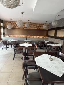 a dining room with tables and chairs and brick walls at Hotel Velky Meder in Veľký Meder