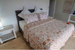 a bedroom with a bed with a red and white comforter at Raitotoka Eco Resort in Matei
