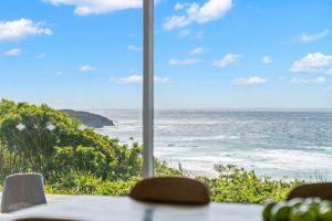 a view of the ocean from a table at Waters Edge - beachside home near Rennies Beach in Ulladulla