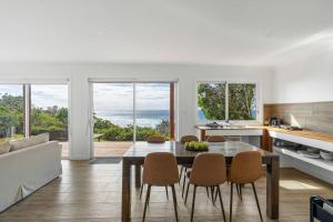 a kitchen and dining room with a table and chairs at Waters Edge - beachside home near Rennies Beach in Ulladulla